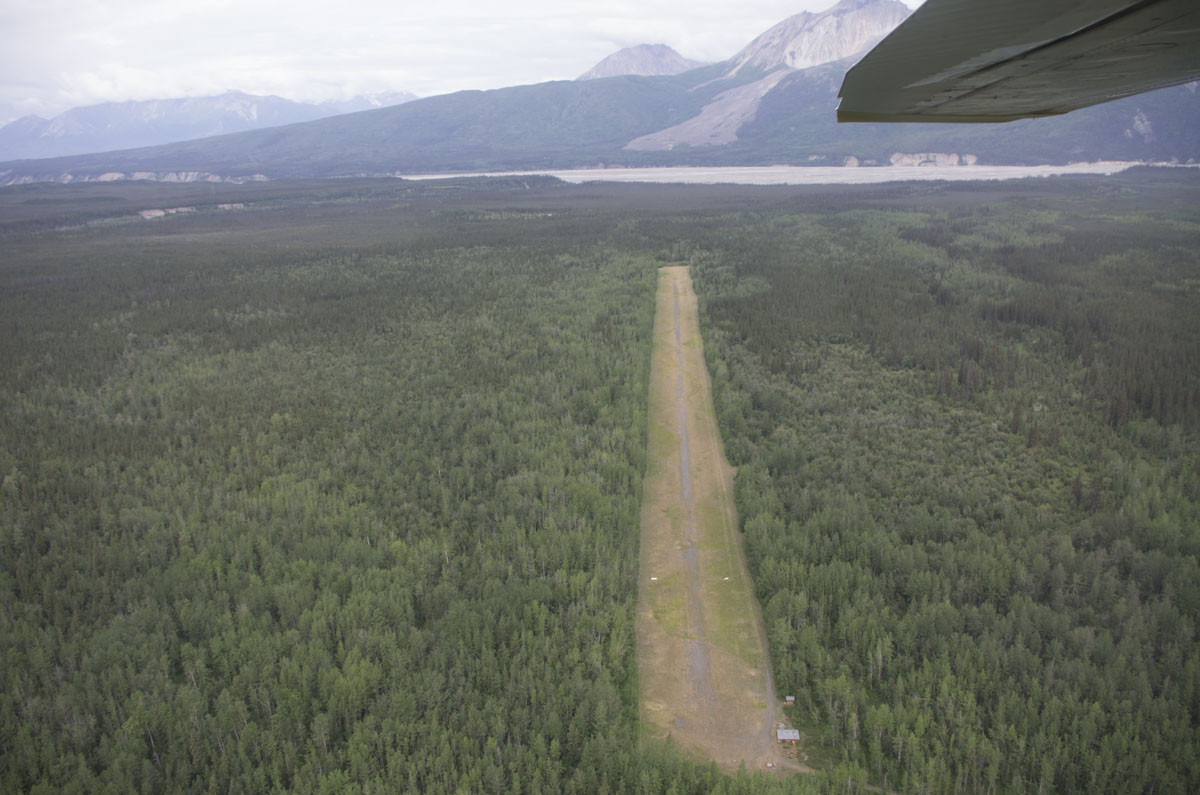 Aerial view of a remote Alaska airstrip through an aircraft window