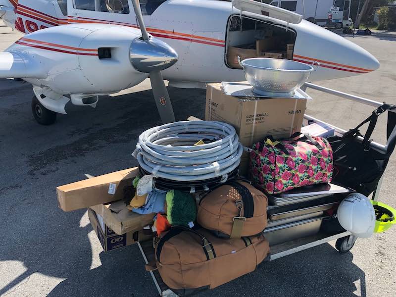Volunteer mission supplies staged beside an aircraft